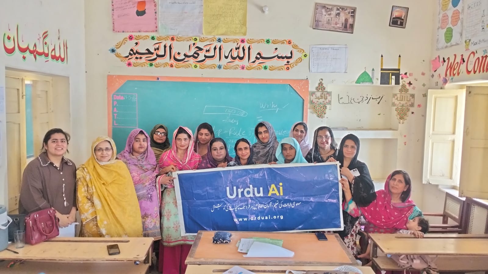 Women standing together with an Urdu Ai banner after a learning session