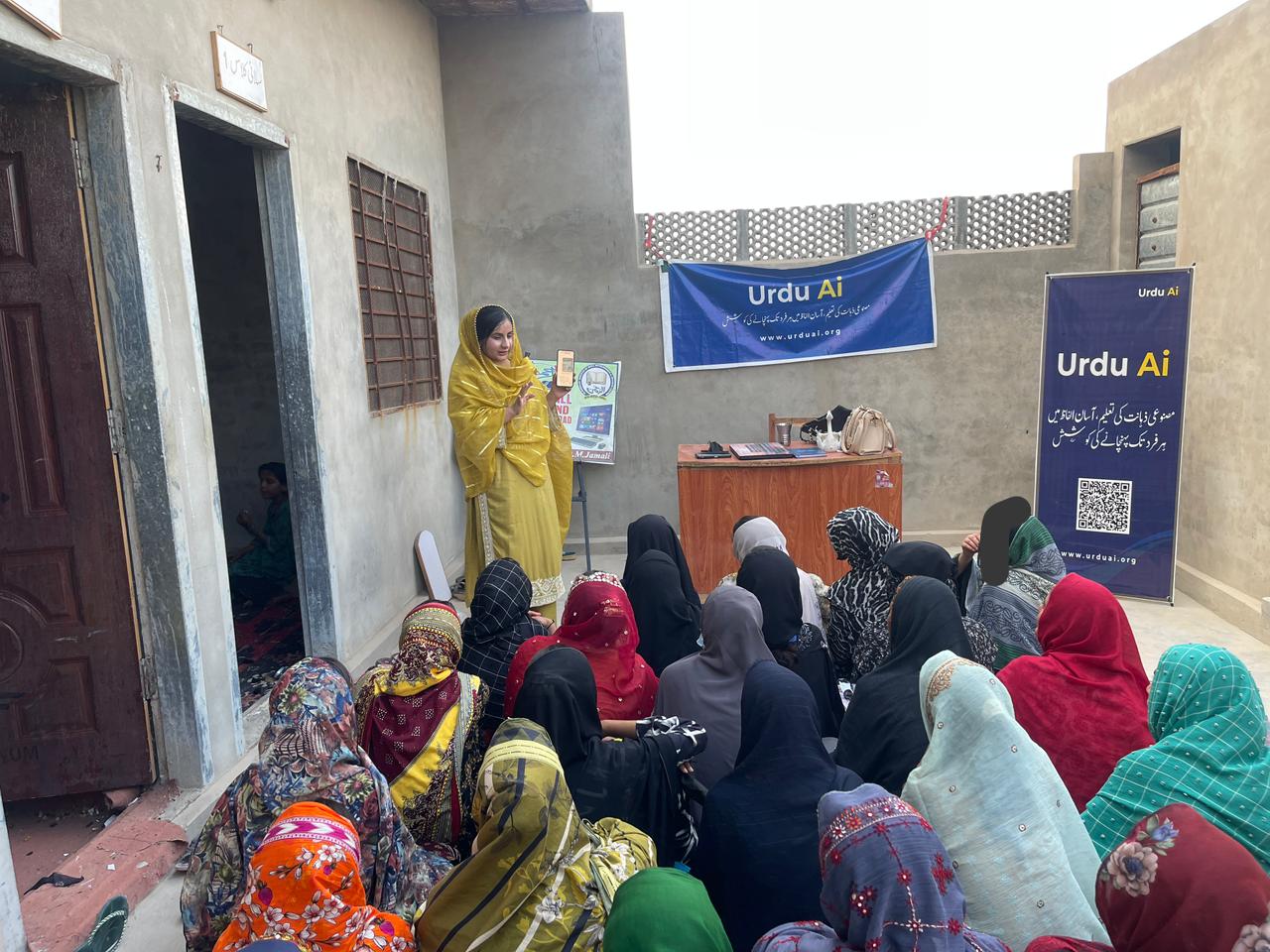 Women attending an Urdu Ai session in a community courtyard